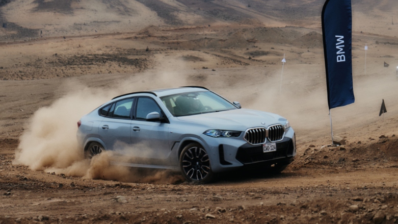 BMW gama X siendo conducido por terreno de tierra